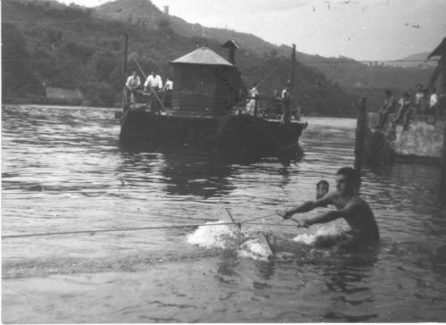 Metà anni '50. Sci d'acqua al Traghetto. Sullo sfondo si intravede la torre dei Colleoni del monte Giglio di Calusco, poi fatta esplodere nell'agosto 1958 per far posto alle cave di marna di Italcementi
